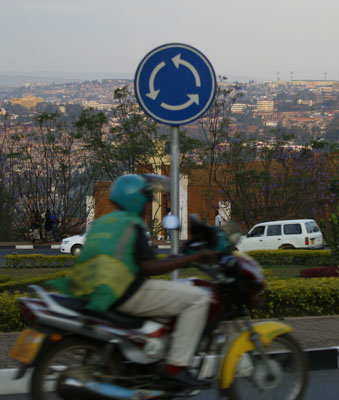 Kjent og kjær rundkøyring med utsikt over Kigali (mot nasjonalstadion). I forgrunnen kjent og kjær moto (sjølv om me berre har lov å køyre dei i Butare). 